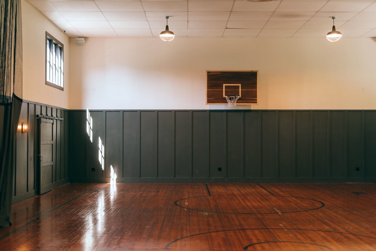Empty indoor sports court with a basketball hoop, unused during off-peak hours